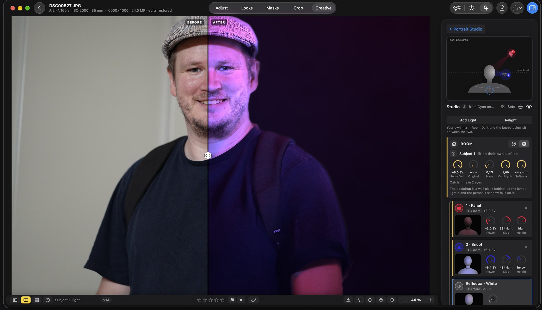 Rebrilo on the Mac, the Creative tab open on the Portrait Studio. A man in a flat cap is split down the middle of his face: on the left, before, the plain snapshot against a white wall; on the right, after, the room gone dark and his face lit in magenta and blue. On the right the Studio rack: a plan of the room with the lamps round a head, then the room's controls, a panel, a snoot and a white reflector, each a card with its own dials.